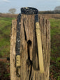 A black and brown BioThane dog collar with a terra splatter design, displayed on a wooden post.